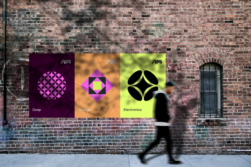 a pedestrian walks by a mural of aimi logos on a wall